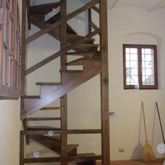 Scala in castagno a chiocciola su base quadrata con pertica centrale cosciali perimetrali e scalini a ventaglio con incasso sulla pertica su due piani