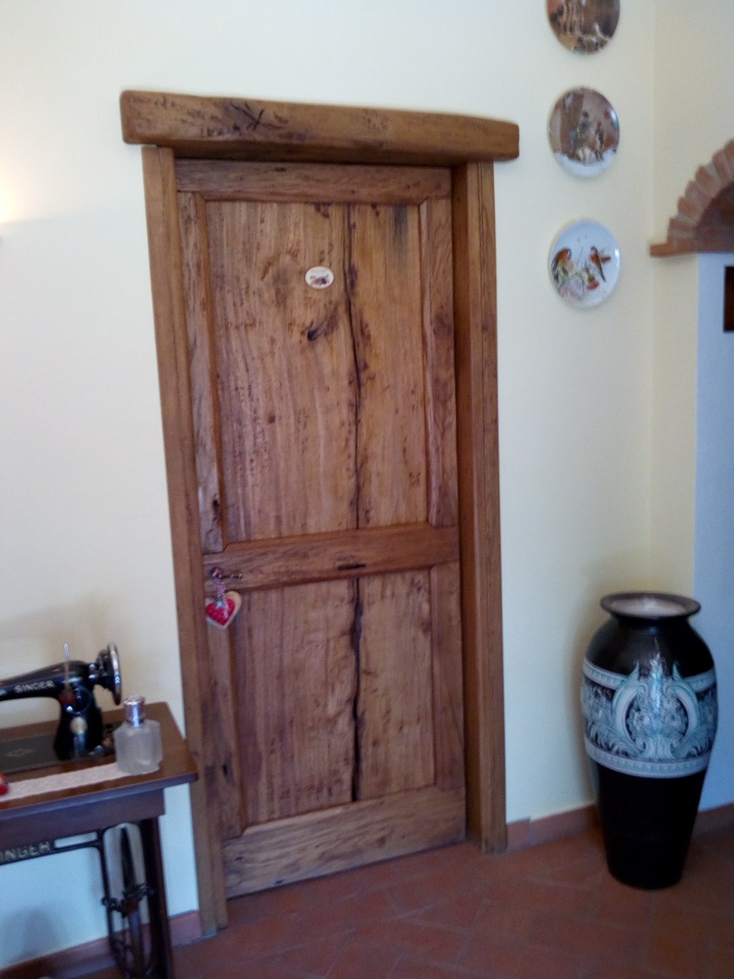 Porta in legno vecchio con ossatura liscia e fasce perimetrali e un traverso con architrave in quercia