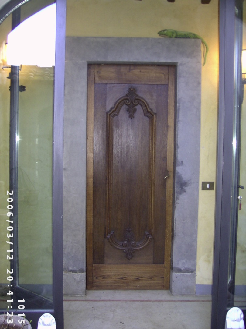 Porta a un anta con fasce di rigiro e formella intagliata