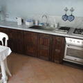 Cucina in castagno stile rustico con piano in marmo bianco 
