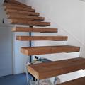 Scala in castagno realizzata con tavoloni in massello da tavola unica montati sospesi- a sbalzo verniciati effetto naturale