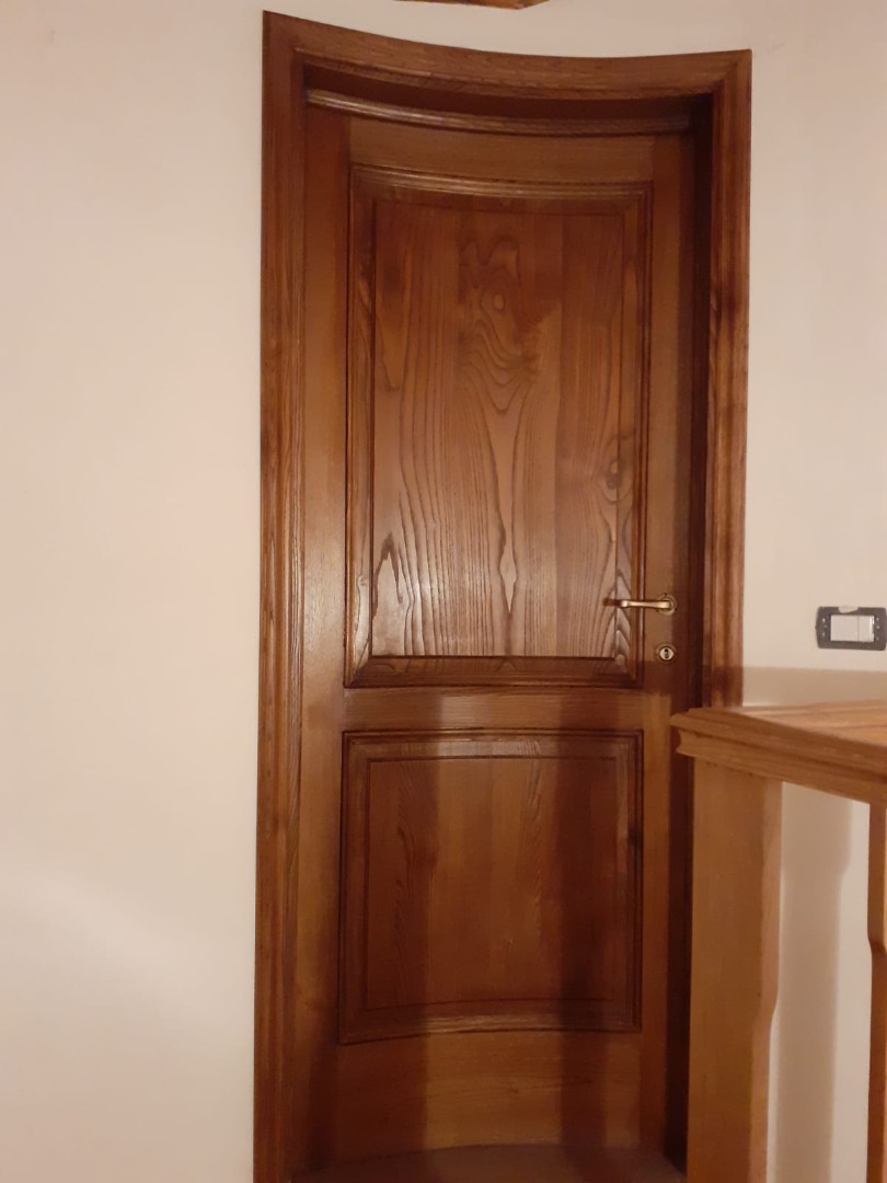 Porta in castagno massello a due formelle curva con imbotte e listre
