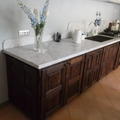 Cucina in castagno stile rustico con piano in marmo bianco